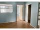 Bedroom with blue walls, hardwood floors, a window, and closet with sliding doors at 5895 18Th N St # 11, St Petersburg, FL 33714