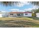 Large backyard showcasing well-maintained lawn, palms, and a charming shed at 619 59Th Ave, St Pete Beach, FL 33706