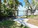 Backyard gate leading to waterfront property with private dock and lush tropical landscaping at 619 59Th Ave, St Pete Beach, FL 33706