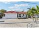 Charming single-story home with a brick driveway, a white facade, and a vibrant red tiled roof at 619 59Th Ave, St Pete Beach, FL 33706