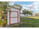 Charming shed nestled in the yard surrounded by lush tropical foliage at 619 59Th Ave, St Pete Beach, FL 33706