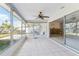 Bright sunroom featuring white tile floors, ceiling fan, and sliding glass doors to outdoor space at 619 59Th Ave, St Pete Beach, FL 33706