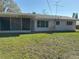 Back exterior of home featuring a screened in porch and large yard at 6223 12Th S St, St Petersburg, FL 33705