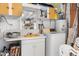 Bright laundry area with vintage washer, yellow sink and white storage at 6353 Spring Hill Dr, Spring Hill, FL 34606