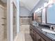 A neutral-toned bathroom with dual sinks, granite counters, a shower, and a soaking tub at 692 Greenglen Ln, Palm Harbor, FL 34684