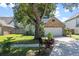 Well-maintained home with a lush green lawn, mature tree, and an inviting brick and siding facade at 692 Greenglen Ln, Palm Harbor, FL 34684