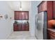 Additional kitchen area featuring dark wood cabinetry, stainless steel refrigerator, and tile flooring at 692 Greenglen Ln, Palm Harbor, FL 34684