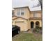 Two-story townhome with light yellow stucco and two-car garage at 6954 Hawthorne Trace Ln, Riverview, FL 33578