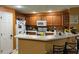 Well-lit kitchen with wooden cabinets, white appliances, and breakfast bar at 6954 Hawthorne Trace Ln, Riverview, FL 33578