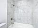 Bright bathroom features a bathtub and shower with marble-look tile surround at 714 Lemonwood Dr, Oldsmar, FL 34677