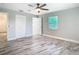 Bedroom featuring ceiling fan, neutral paint, wood-look floors, window, and closet at 714 Lemonwood Dr, Oldsmar, FL 34677