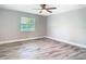 Spacious bedroom featuring luxury vinyl flooring, ceiling fan, and a large window at 714 Lemonwood Dr, Oldsmar, FL 34677