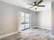 Bedroom with sliding glass doors, modern ceiling fan, and luxury vinyl plank flooring at 714 Lemonwood Dr, Oldsmar, FL 34677