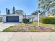 Charming single-story home with a black garage door and a gated front entrance at 714 Lemonwood Dr, Oldsmar, FL 34677