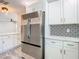 Kitchen featuring stainless steel appliances, granite countertops, and white cabinets at 714 Lemonwood Dr, Oldsmar, FL 34677