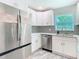 Newly remodeled kitchen featuring stainless steel appliances, new flooring, and white shaker cabinets with a designer backsplash at 714 Lemonwood Dr, Oldsmar, FL 34677