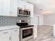 Beautiful kitchen with stainless steel appliances, stylish backsplash, and modern finishes, open to the living area at 714 Lemonwood Dr, Oldsmar, FL 34677