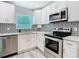 Bright kitchen featuring stainless appliances, modern backsplash, and white cabinets for a clean, contemporary look at 714 Lemonwood Dr, Oldsmar, FL 34677