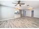 Open-concept living room with modern wood-look floors and a ceiling fan at 714 Lemonwood Dr, Oldsmar, FL 34677