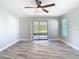 A spacious living room featuring gray floors, a fan, and a sliding glass door at 714 Lemonwood Dr, Oldsmar, FL 34677