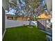 Well-maintained artificial grass yard featuring a tree, a swing, and a white fence at 7325 S Trask St, Tampa, FL 33616