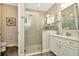 Bathroom featuring white cabinets, wood-look floors, and a glass shower enclosure at 7426 Sungold Meadow Ct, Apollo Beach, FL 33572