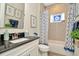 Bathroom with dark granite countertop, white cabinets, and tub with blue accents at 7426 Sungold Meadow Ct, Apollo Beach, FL 33572