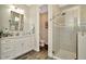 Bathroom featuring white cabinets, wood-look floors, and a walk-in shower at 7426 Sungold Meadow Ct, Apollo Beach, FL 33572