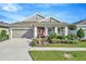 Charming single-story home featuring a manicured lawn, complemented by tasteful landscaping and an attached two-car garage at 7426 Sungold Meadow Ct, Apollo Beach, FL 33572