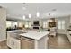 Modern kitchen with stainless steel appliances, a center island, bright lighting, and an open view to the living area at 7426 Sungold Meadow Ct, Apollo Beach, FL 33572