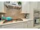 Close-up of a well-appointed kitchen with stainless steel appliances, a gas cooktop, and decorative tile backsplash at 7426 Sungold Meadow Ct, Apollo Beach, FL 33572