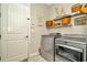 Modern laundry room equipped with sleek silver appliances and stylish shelving at 7426 Sungold Meadow Ct, Apollo Beach, FL 33572