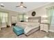 Serene main bedroom featuring a comfortable bed, soft lighting, large windows, and a peaceful ambiance with wood floors at 7426 Sungold Meadow Ct, Apollo Beach, FL 33572