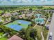 Aerial view of neighborhood showcasing community pool, tennis courts, and surrounding residential area at 7645 Windchase Way, Wesley Chapel, FL 33545