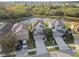 Aerial view of a gray home, with well-kept lawn, surrounded by lush greenery and a tranquil pond at 7645 Windchase Way, Wesley Chapel, FL 33545