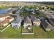 Aerial view of a neighborhood featuring well-maintained lawns, a community pool, and lush greenery at 7645 Windchase Way, Wesley Chapel, FL 33545