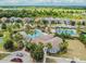 Aerial view of the community pool and clubhouse surrounded by palm trees and well-maintained landscaping at 7645 Windchase Way, Wesley Chapel, FL 33545