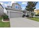 Two-story home with a paved driveway, two car garage and neatly landscaped yard at 7645 Windchase Way, Wesley Chapel, FL 33545