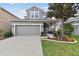 Two-story home boasts a manicured front yard, gray siding and a two-car garage at 7645 Windchase Way, Wesley Chapel, FL 33545