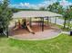 Aerial view of a community playground area with slides, swings, and shaded seating at 7645 Windchase Way, Wesley Chapel, FL 33545