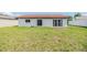 Lush backyard featuring a well-maintained lawn and an exterior view of a home with a red tile roof at 8705 Tahiti Ln, Tampa, FL 33615