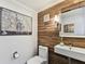 Stylish half-bathroom with wood-look accent wall, vessel sink, and modern fixtures at 9012 Antigua Dr, Seminole, FL 33777