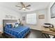 Bright bedroom with a ceiling fan, dark wood floors, and blue and white bedding at 9012 Antigua Dr, Seminole, FL 33777