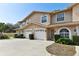 Two-story townhome with attached garages, tidy landscaping, and light stucco exterior at 9012 Antigua Dr, Seminole, FL 33777