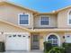 Light stucco two-story townhome featuring a one-car garage and tidy landscaping at 9012 Antigua Dr, Seminole, FL 33777