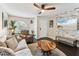 Relaxing living room with stylish dark floors, a ceiling fan, and a beach themed television accent wall at 9012 Antigua Dr, Seminole, FL 33777