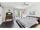 Bright main bedroom featuring dark wood floors, a ceiling fan, and balcony access with sliding glass doors at 9012 Antigua Dr, Seminole, FL 33777