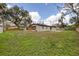 Large backyard featuring a covered patio, expansive lawn and wooden fence at 934 W Wheeler Rd, Brandon, FL 33510