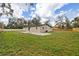 Back of house with a concrete patio overlooking a sprawling yard enclosed by a wooden fence at 934 W Wheeler Rd, Brandon, FL 33510