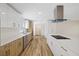 Modern kitchen with stainless steel appliances, white countertops, and white and wood cabinets with gold handles at 934 W Wheeler Rd, Brandon, FL 33510